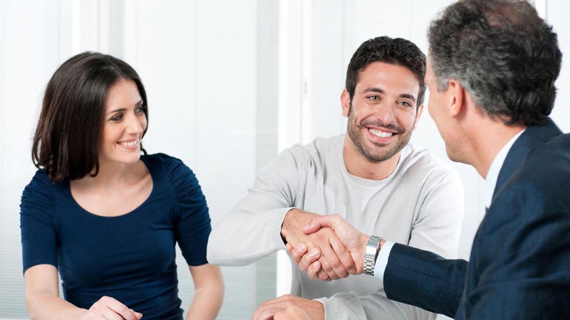 image of a salesman shaking hands with a man with a woman